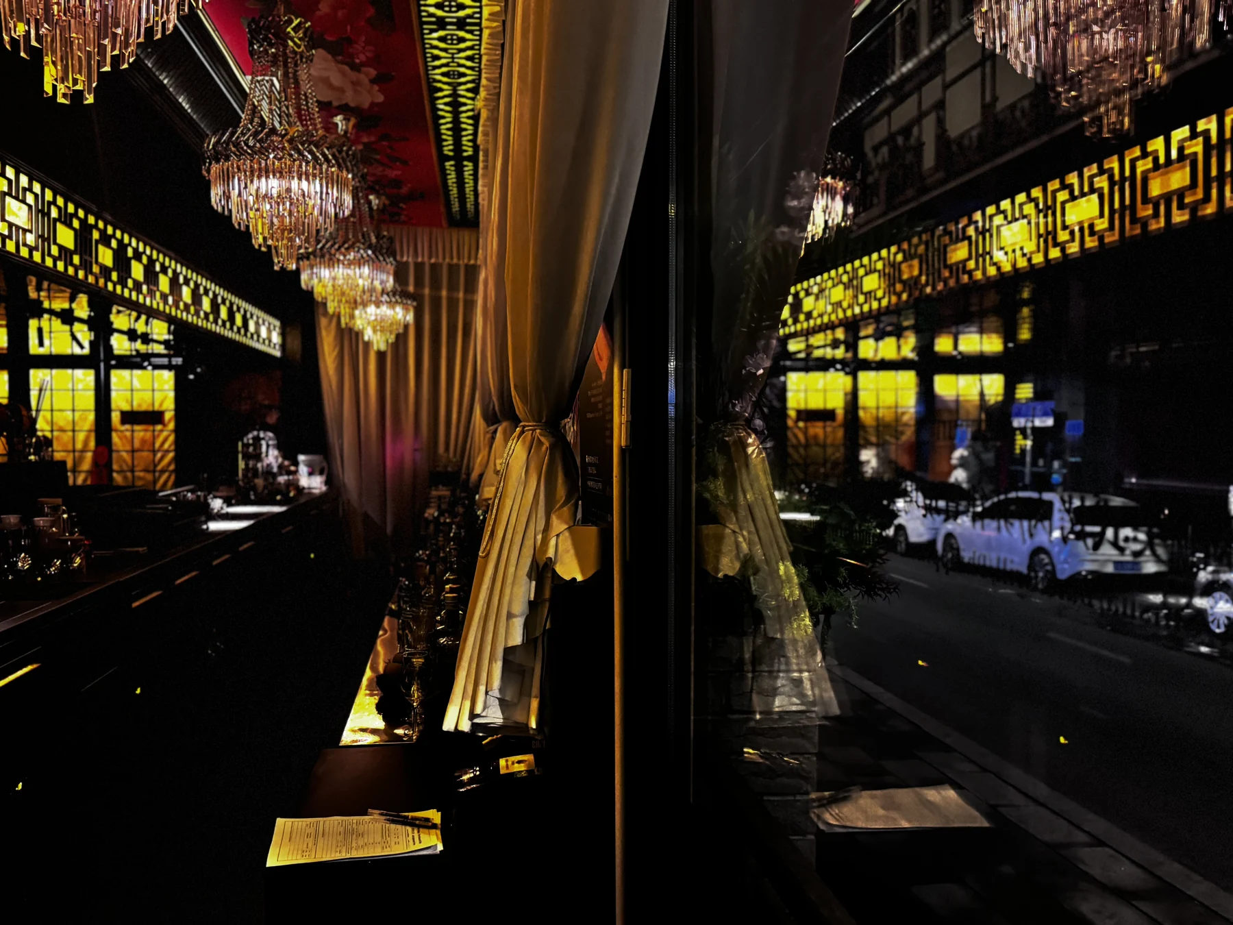 金色帷幕与窗中倒映的 BAR WEST 灯光和街景